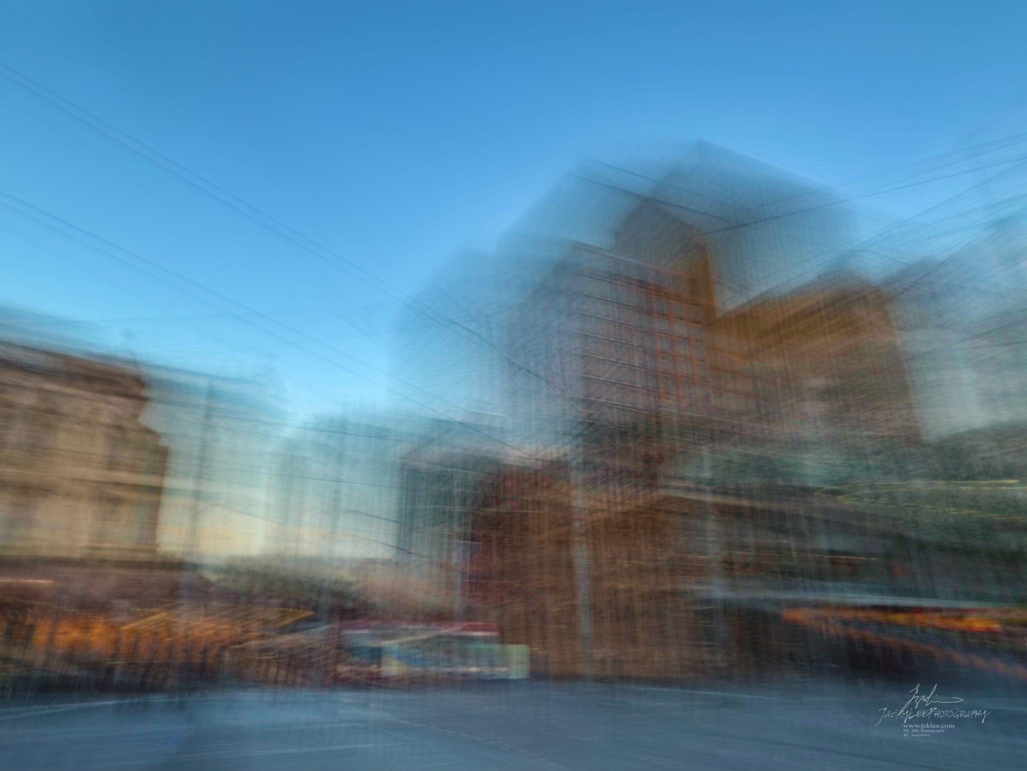 Buildings woven into vertical threads under clear blue sky, George Street, Sydney, an Intentional Camera Movement photograph made on a phone by Jacky Lee